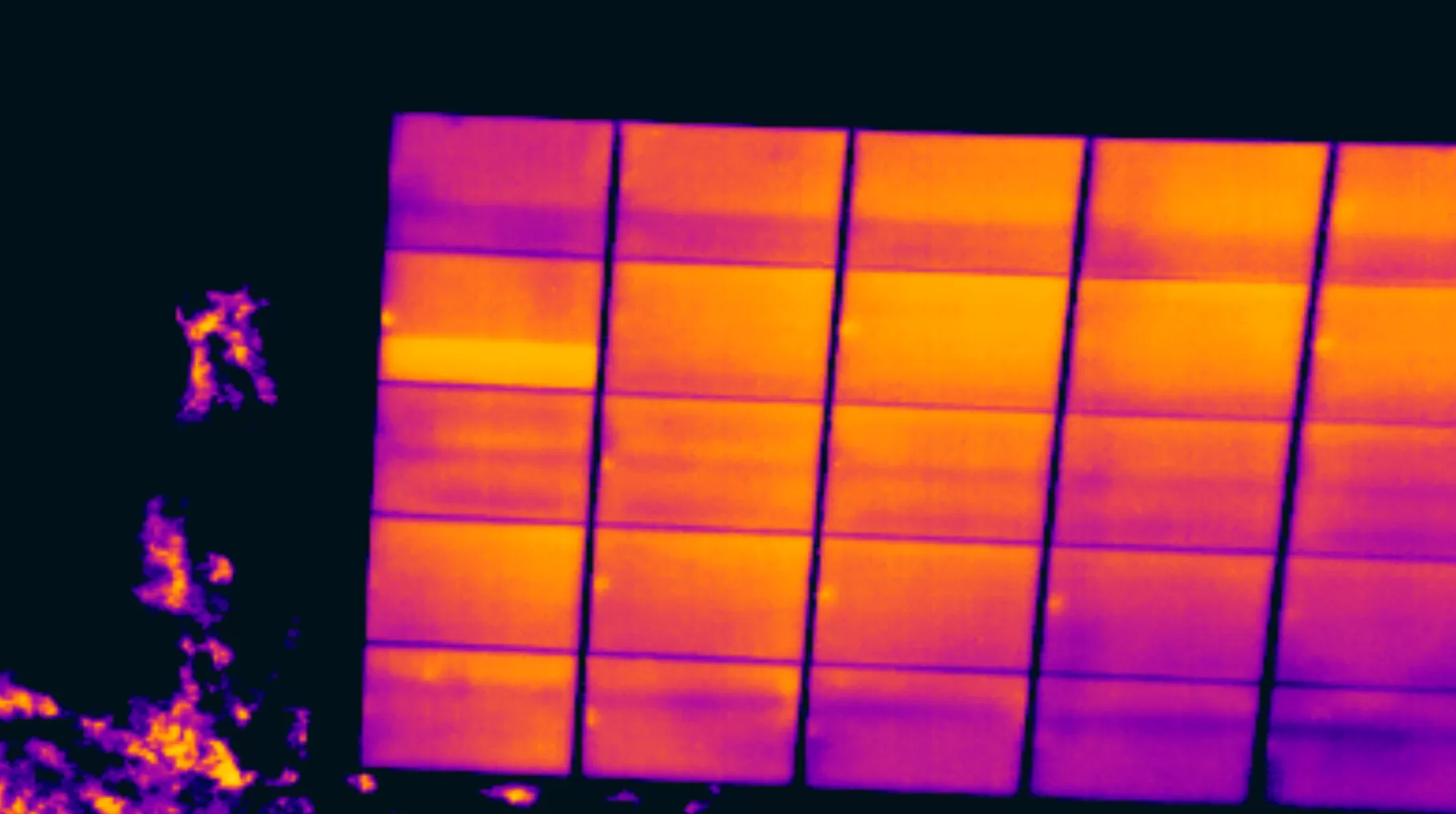 PV Solar Panel Diode Fault Aerial thermal image of a commercial rooftop solar array showing a warm anomaly against cooler surrounding modules